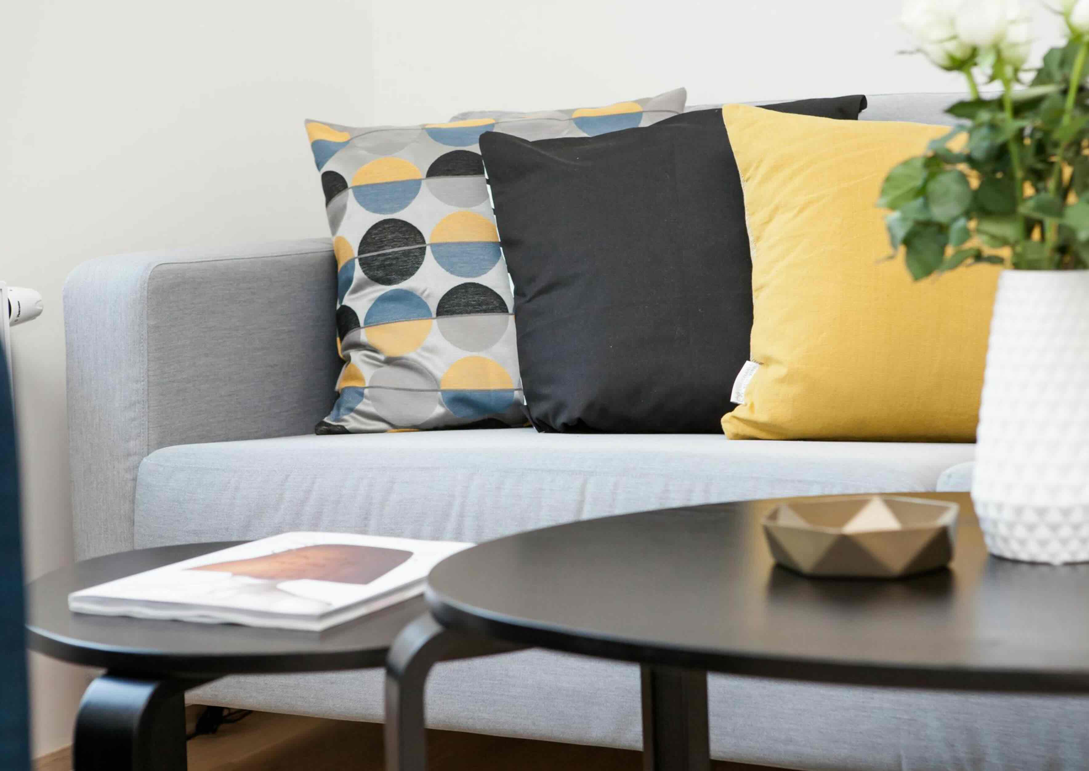 Woman using a laptop while sitting on the couch.